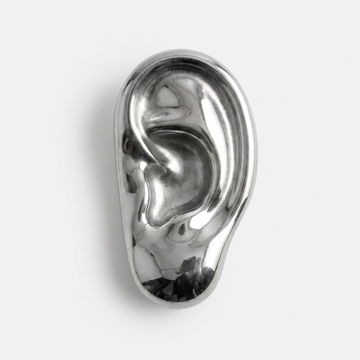Vincent's Ear bottle opener in polished silver, styled on a table